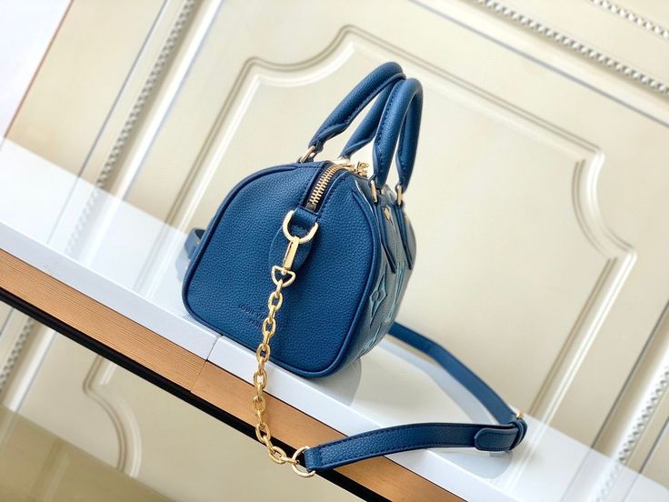 Embrace iconic style with a modern twist in this Nano Speedy-inspired handbag. Crafted in a captivating deep blue hue, this compact bag is adorned with a reimagined monogram print in a contrasting lighter blue, adding a playful touch. The gold-tone hardware complements the color scheme beautifully, while the detachable shoulder strap offers versatile carrying options. High-end Blue Shoulder Bag For Travel, High-end Blue Crossbody Shoulder Bag, High-end Blue Shoulder Bag With Top Carry Handle, High-end Blue Shoulder Bag With Detachable Strap, High-end Blue Bag With Detachable Handle, High-end Blue Satchel Shoulder Bag, High-end Blue Shoulder Bag With Removable Pouch, High-end Blue Satchel For Everyday Use, High-end Blue Satchel For Everyday