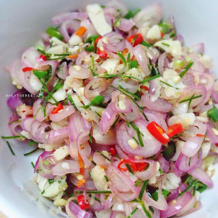 a white bowl filled with onions and red peppers