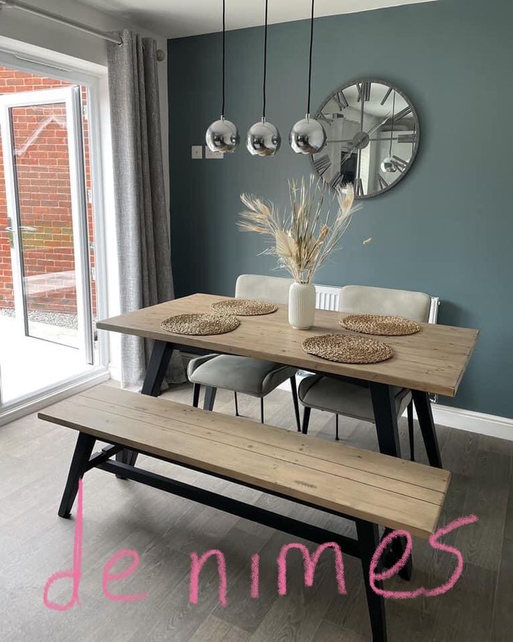 a wooden table sitting under a mirror next to a window