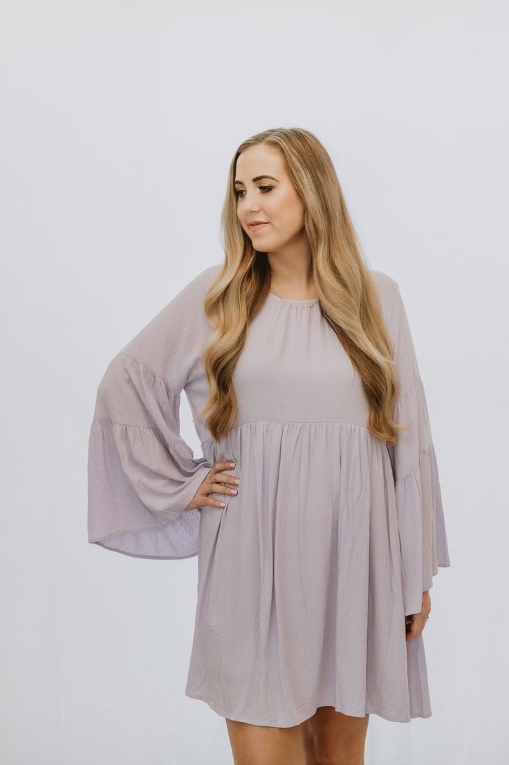 This is a lavender long sleeve flowy dress with bell sleeves and a keyhole tie back. The model is wearing a size small. Long Sleeve Flowy Dress, Dress With Bell Sleeves, Bell Sleeve Dress, The Model, Flowy Dress, Tie Backs, Tie Back, Clothes For Sale, Bell Sleeves