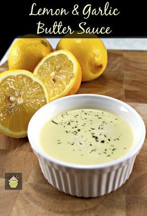 lemon and garlic butter sauce in a white bowl on a cutting board next to sliced lemons