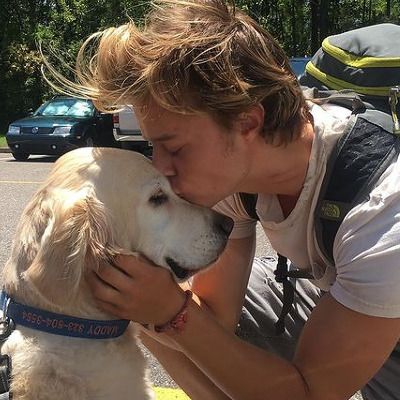 a man is kissing his dog on the street