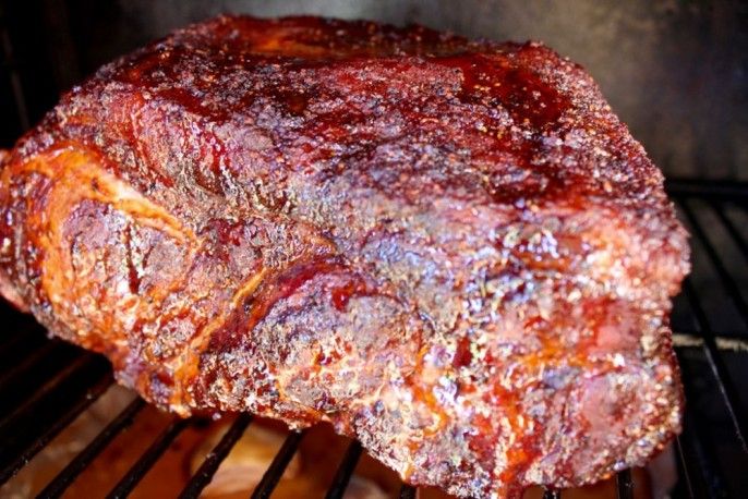 a large piece of meat sitting on top of a white plate next to a window