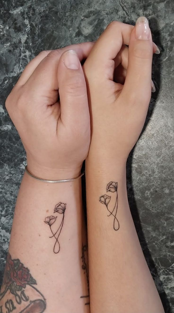 two people with matching tattoos on their arms