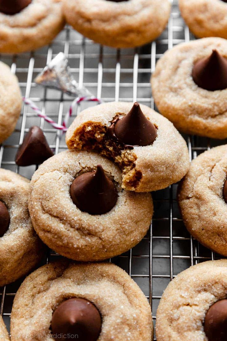 chocolate chip cookies on a cooling rack with one bite taken out and the other half eaten