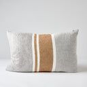 a white and tan striped pillow sitting on top of a table