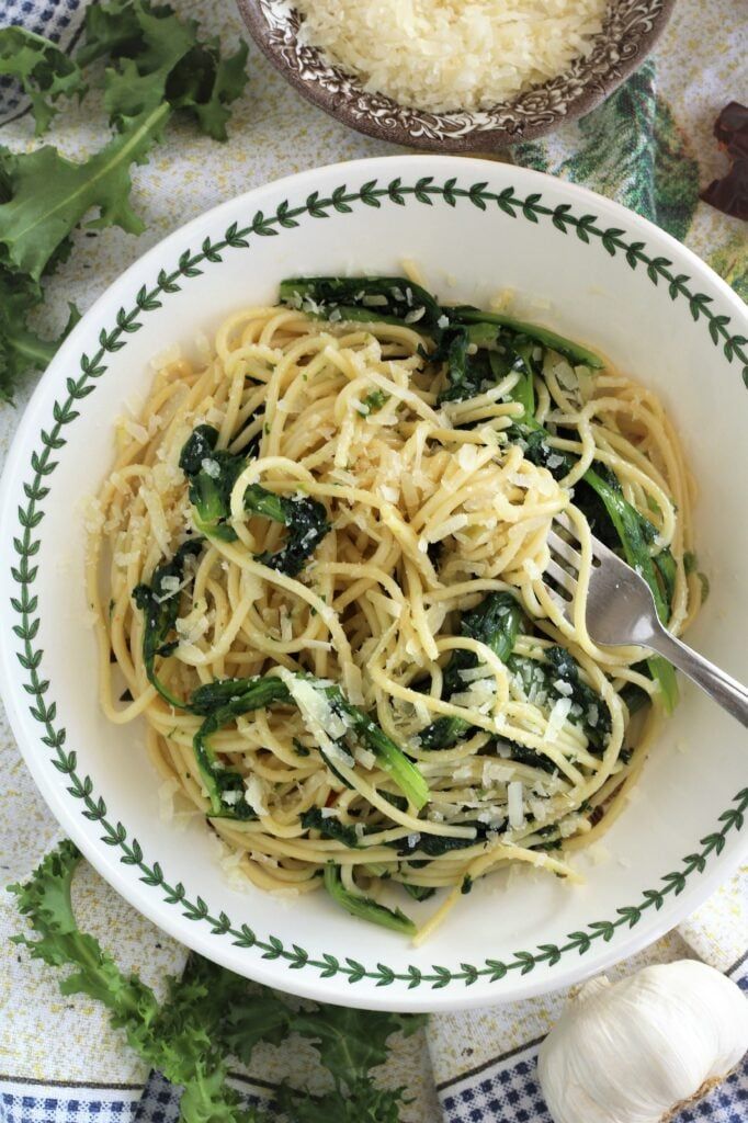 spaghetti with garlic and spinach in a white bowl