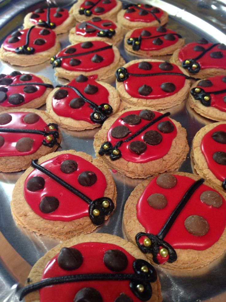 ladybug cookies are arranged in rows on a tray