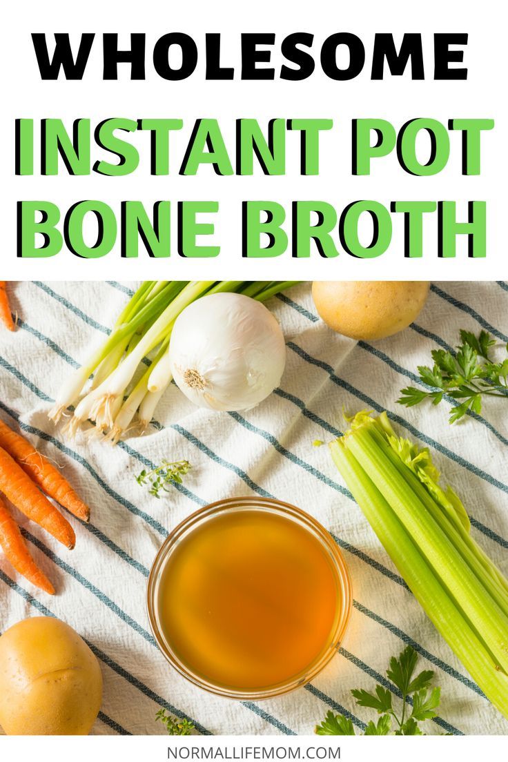 a bowl of broth next to carrots and celery