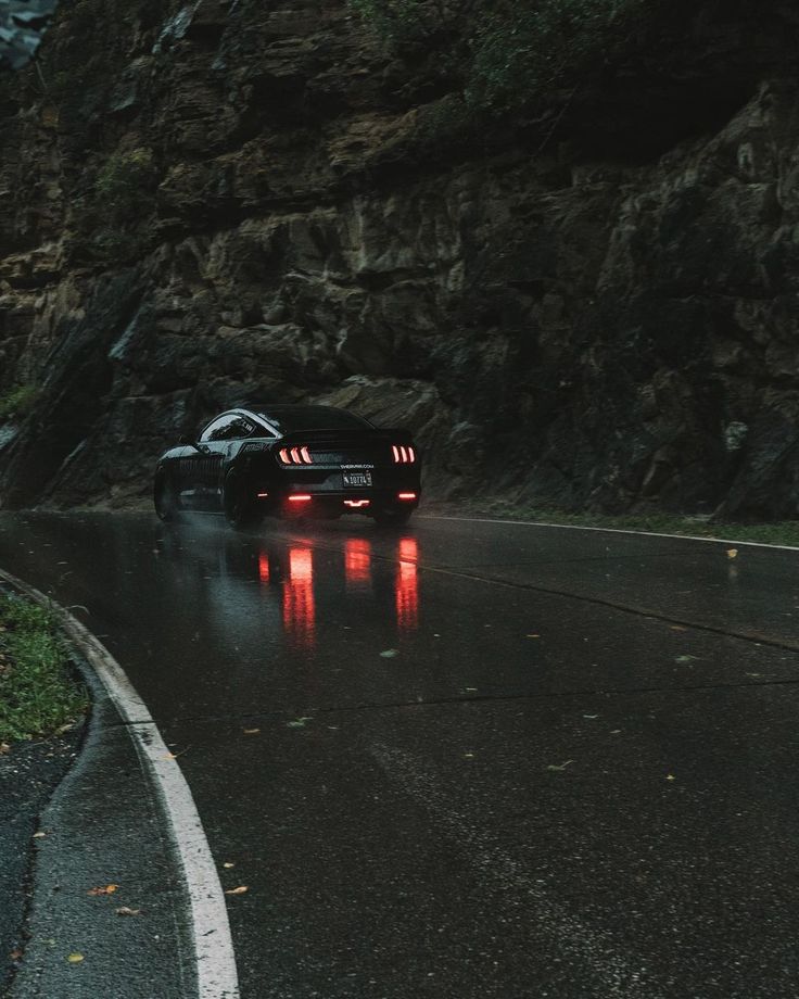 a car driving down the road in the rain