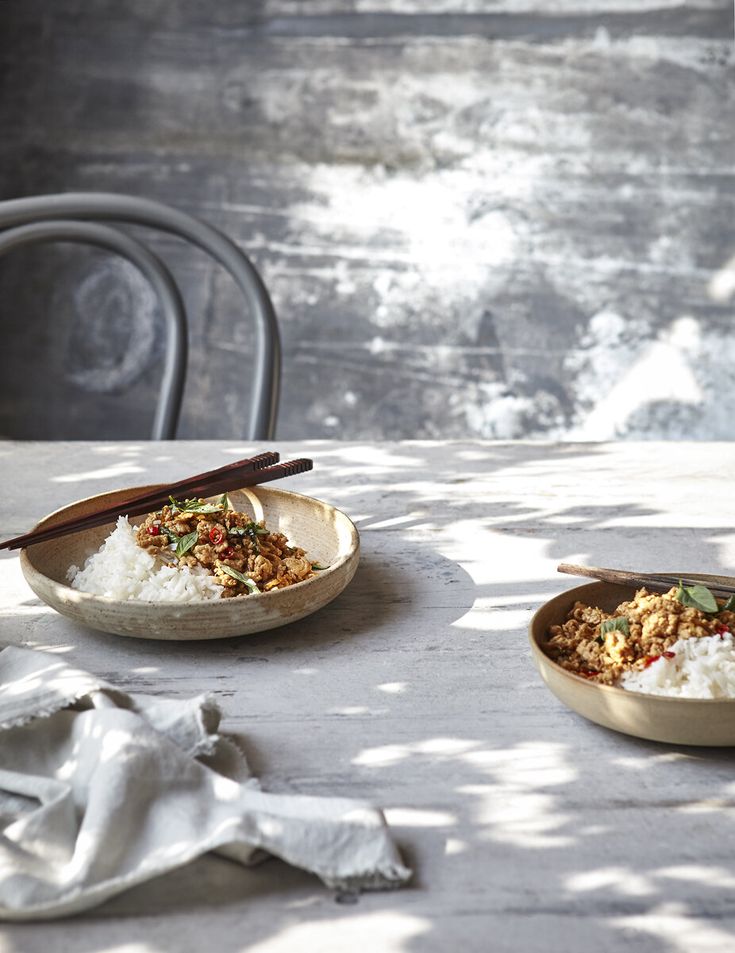 two bowls filled with food sitting on top of a table