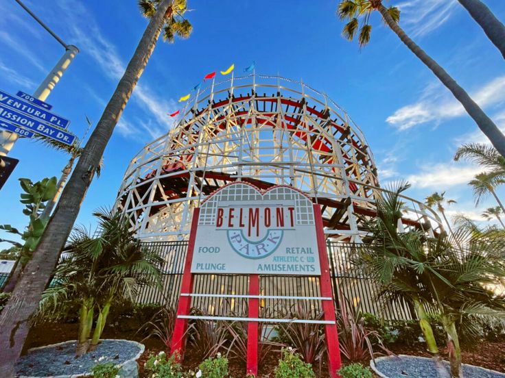 the sign for belmont park in front of palm trees and blue sky with white clouds