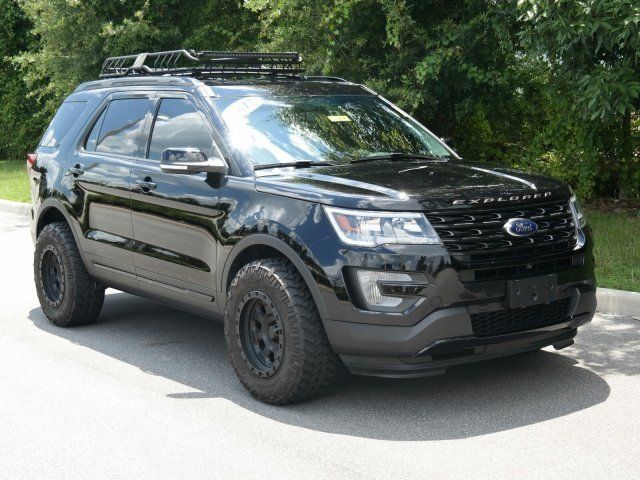 a black suv is parked on the side of the road in front of some trees