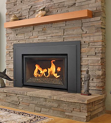 a fire place in the middle of a living room with wood flooring and stone fireplace