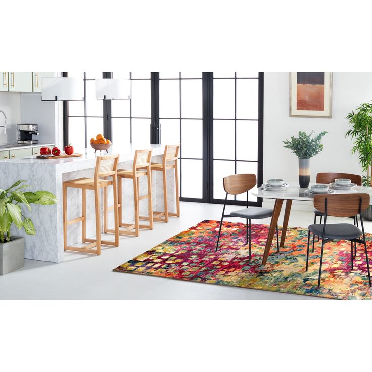 a dining room table with four chairs and a rug in front of the counter top