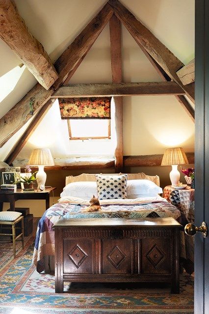 a bed sitting under a window in a bedroom next to two lamps on either side of the bed