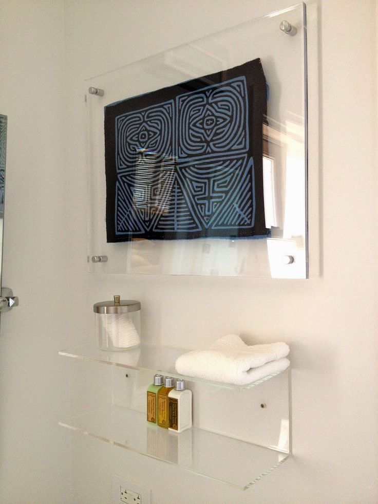 a bathroom with a glass shelf and mirror