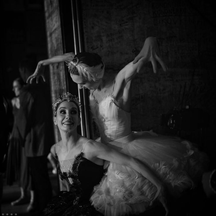 two ballerinas in black and white pose for the camera