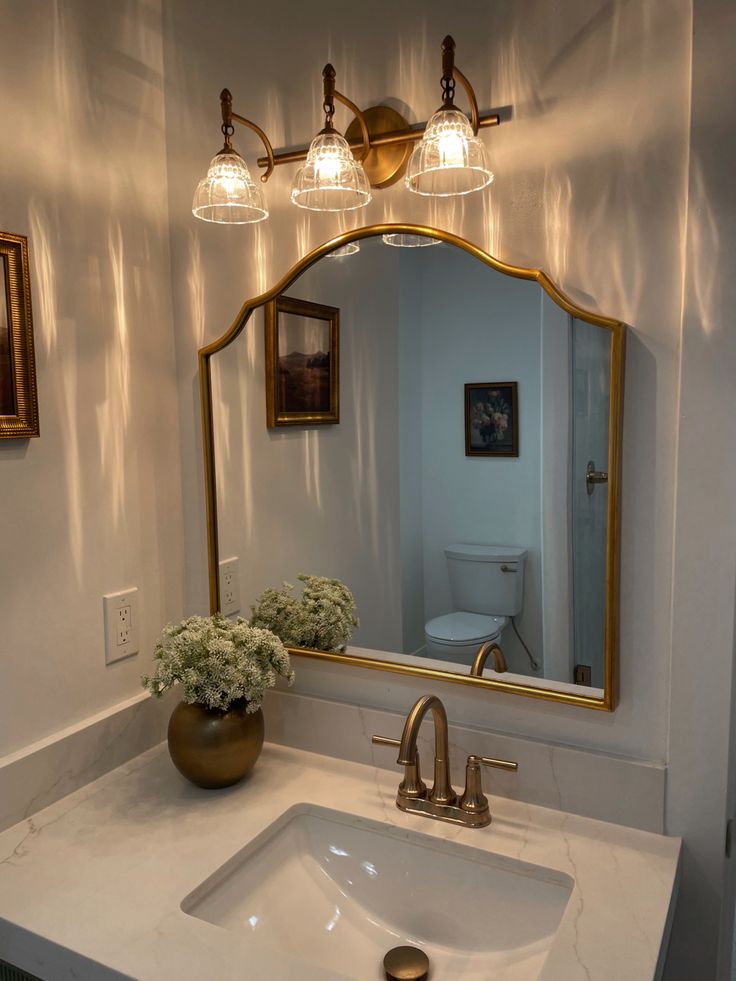 a bathroom sink with a mirror and lights above it