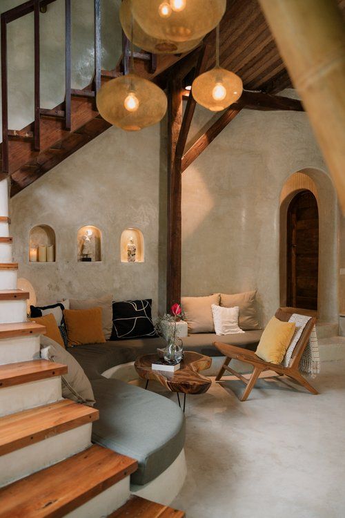 a living room filled with furniture and wooden stairs