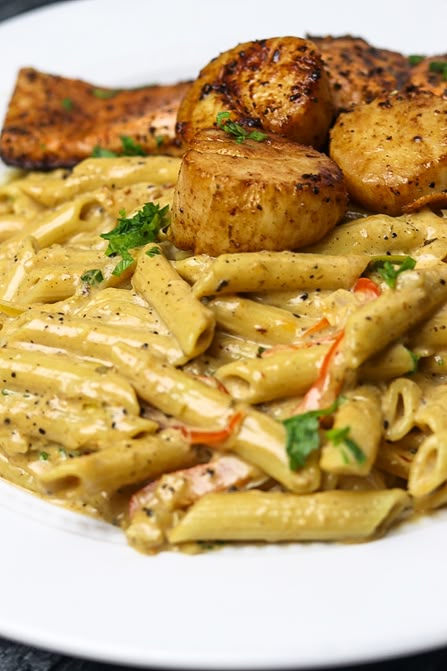 a white plate topped with pasta and meat