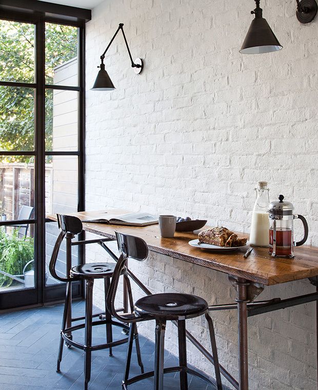 a table with food and drinks on it in front of a brick wall that reads house & home