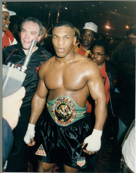 a man in a boxing ring surrounded by people