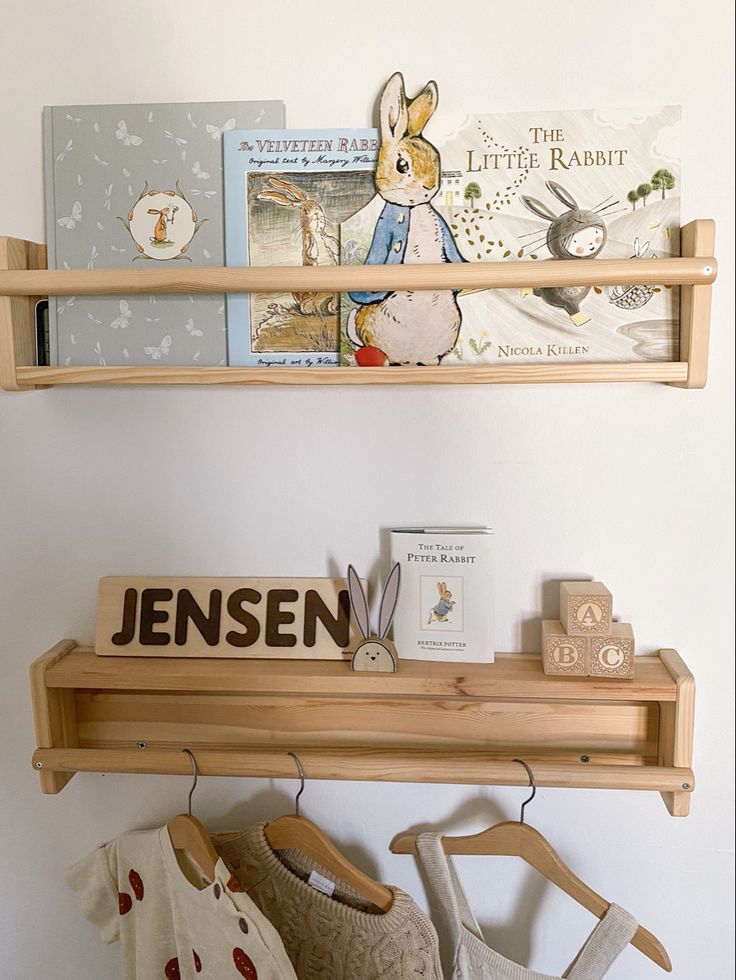 two wooden shelves holding children's books and other items on top of each shelf