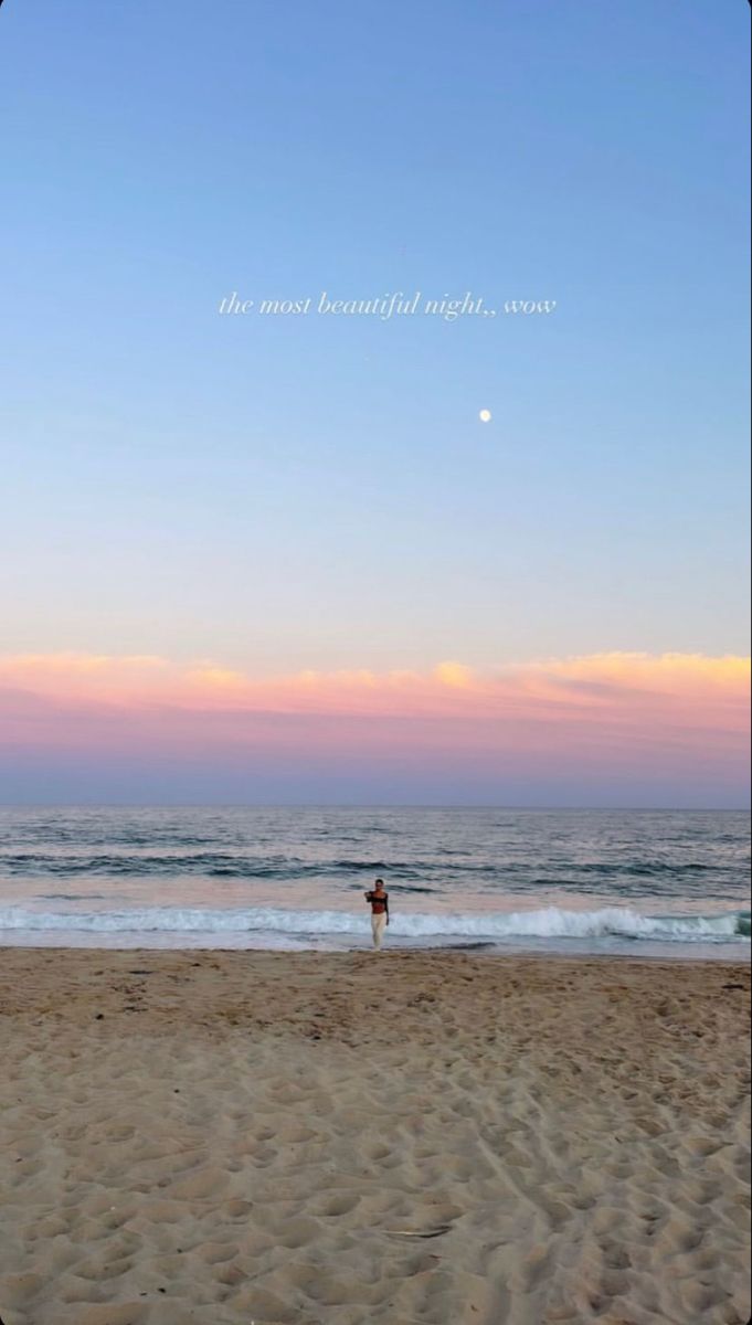 a person standing on top of a sandy beach next to the ocean