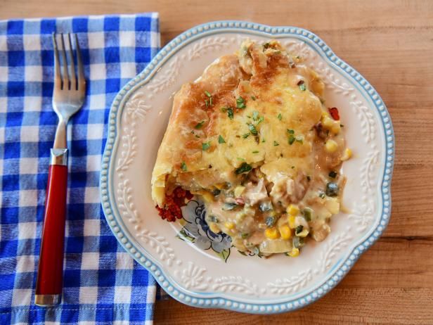 a white plate topped with an omelet next to a blue and white checkered napkin