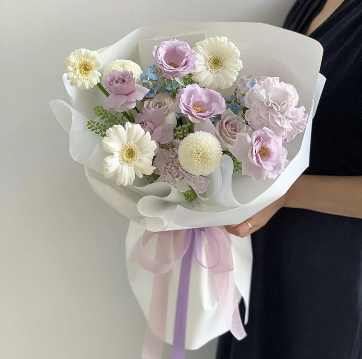 a woman holding a bouquet of flowers in her hand