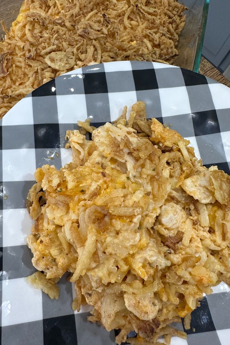 a white plate topped with fried food on top of a checkered table cloth