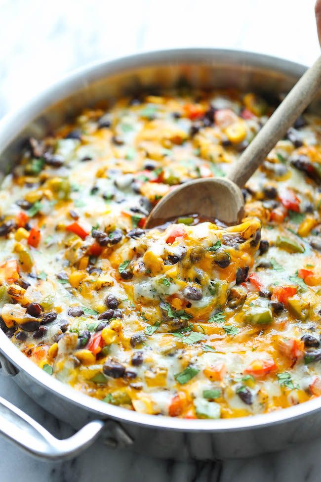 a large pot filled with mexican food and a wooden spoon sticking out of the top