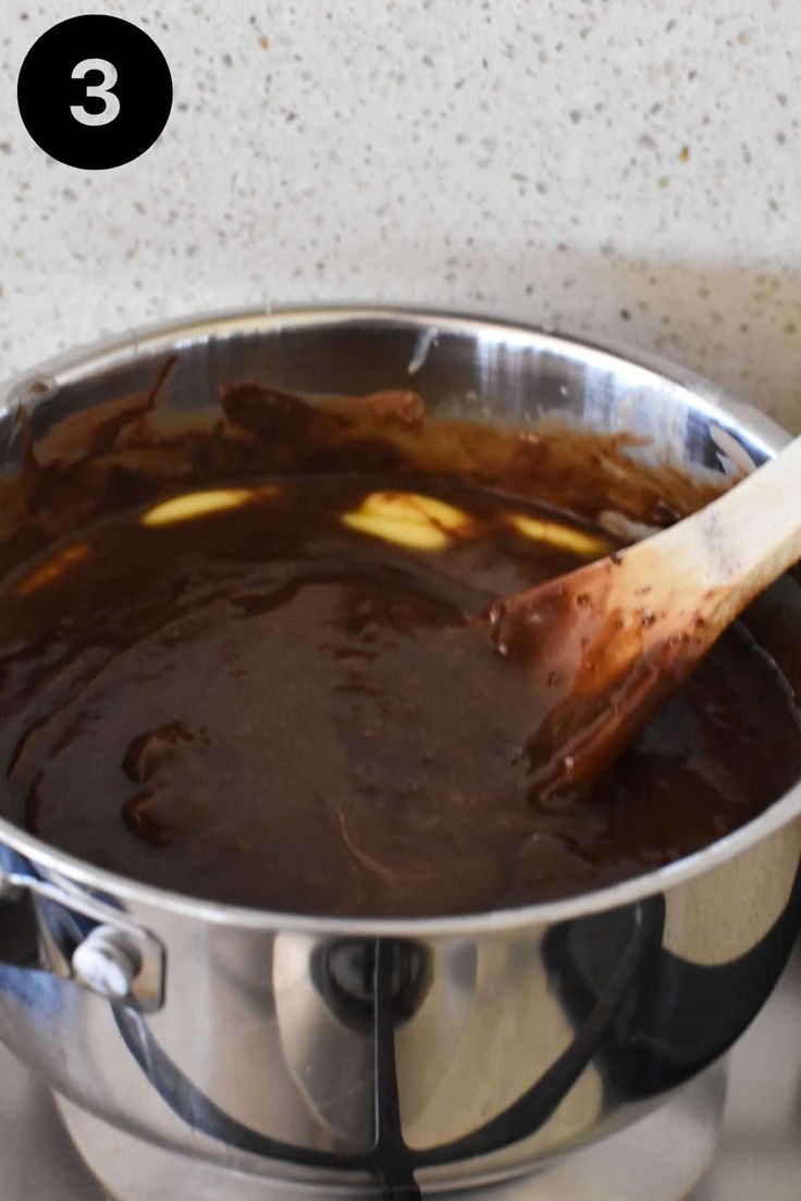 a pot filled with sauce and a wooden spoon