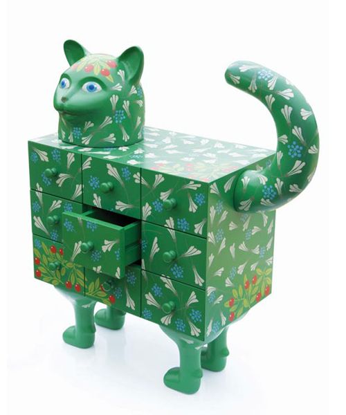 a green cat shaped box sitting on top of a white floor next to a drawer