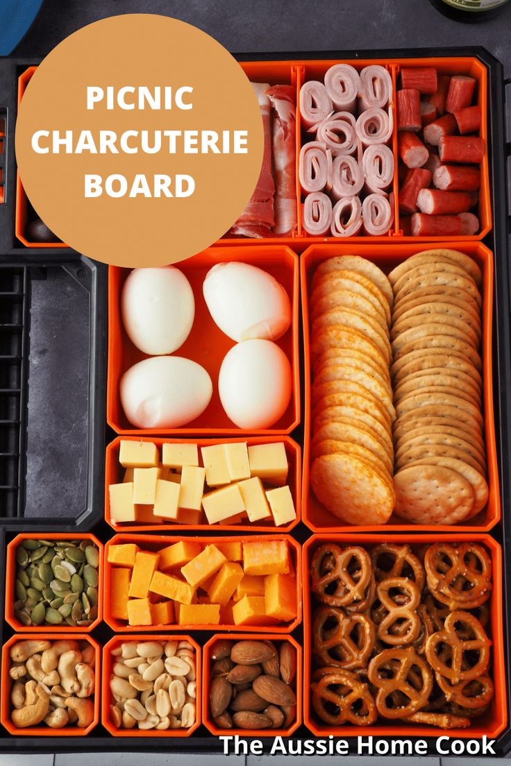 an orange plastic container filled with different types of food and words picnic charcuterie board