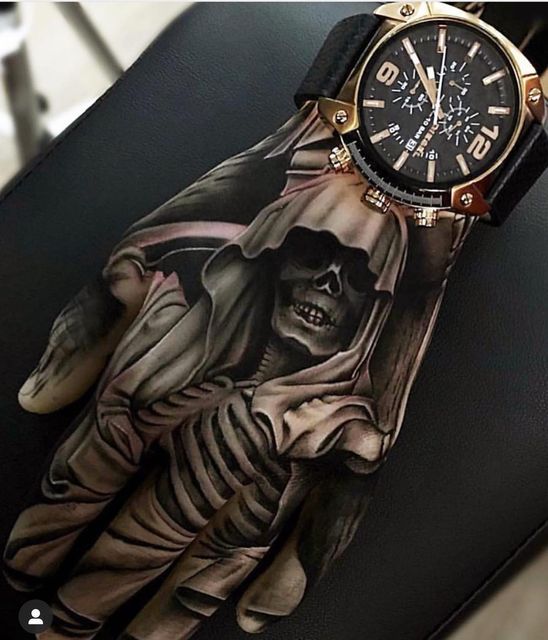 a person's hand with a skeleton tattoo on it and a watch in the background