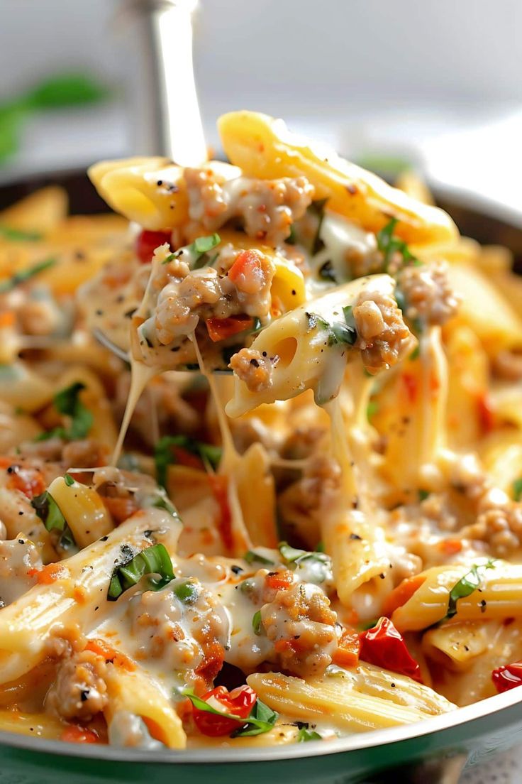 a spoon full of pasta with meat and vegetables