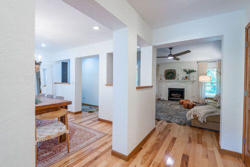 an empty living room with wood floors and white walls