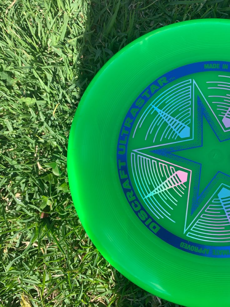 a green frisbee laying in the grass on top of it's side