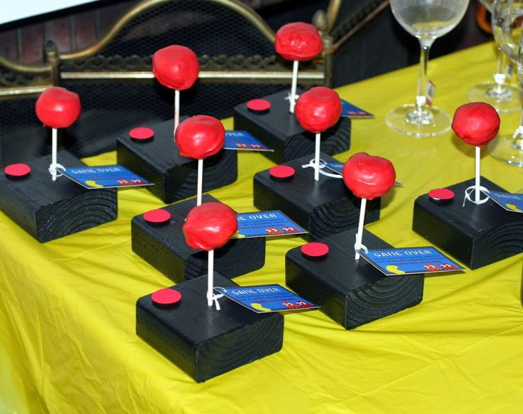 a table topped with lots of red lollipops on top of black blocks