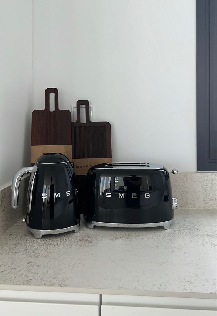 two black toasters sitting on top of a counter