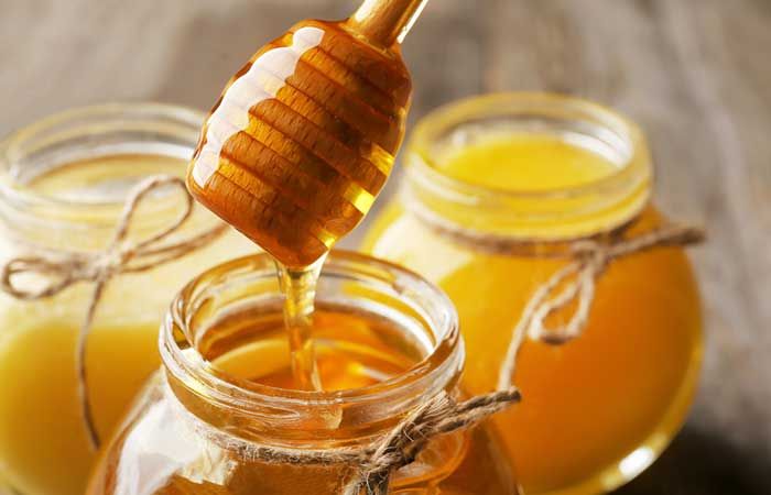 honey is being poured into jars filled with liquid