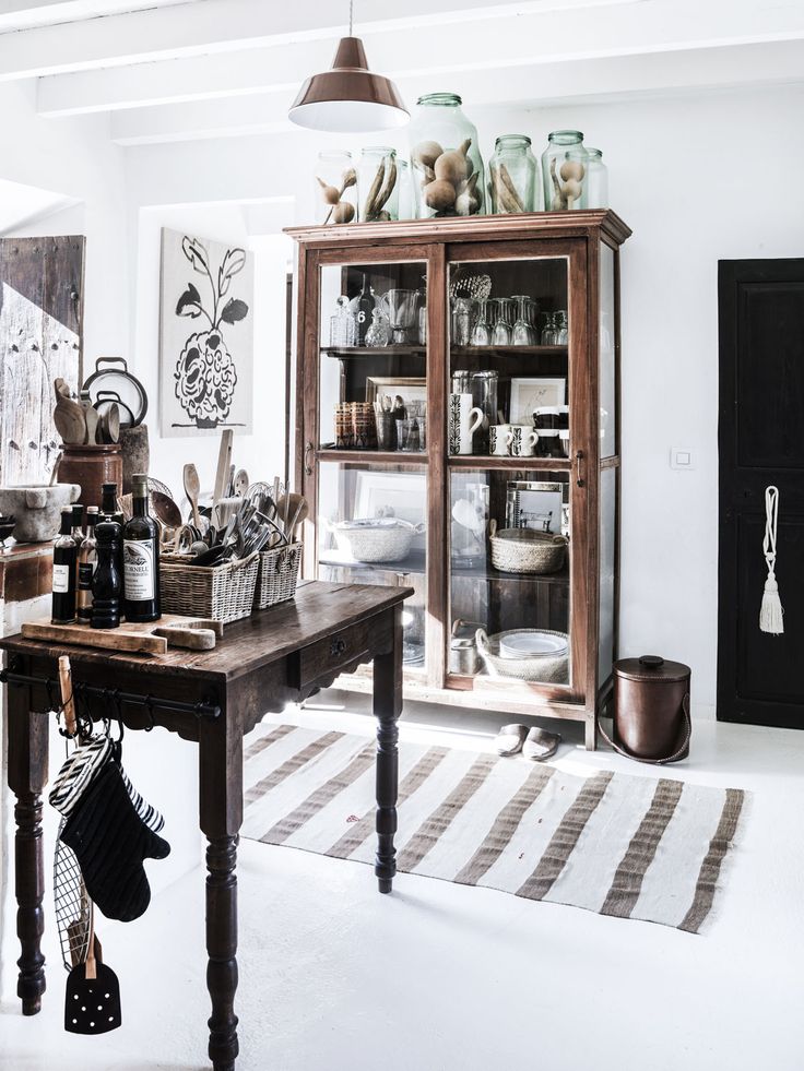 an old fashioned kitchen with lots of dishes on the table