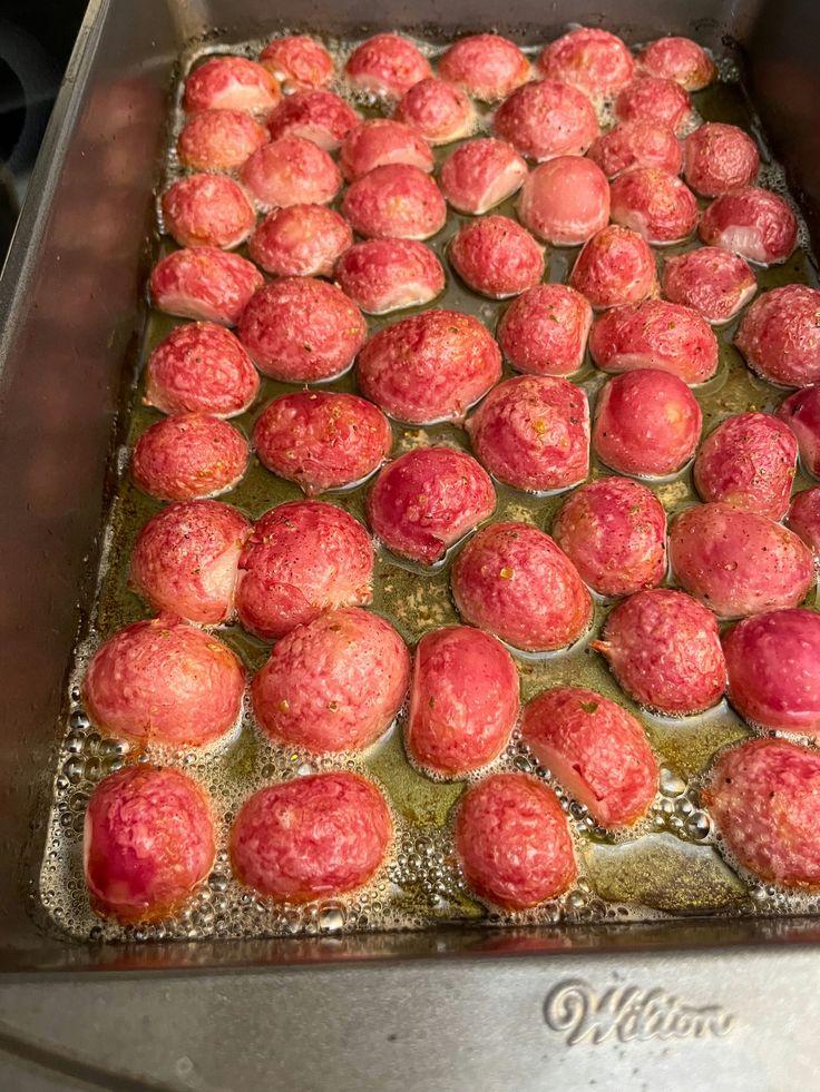 there are many balls of food on the stove in the pan, ready to be cooked