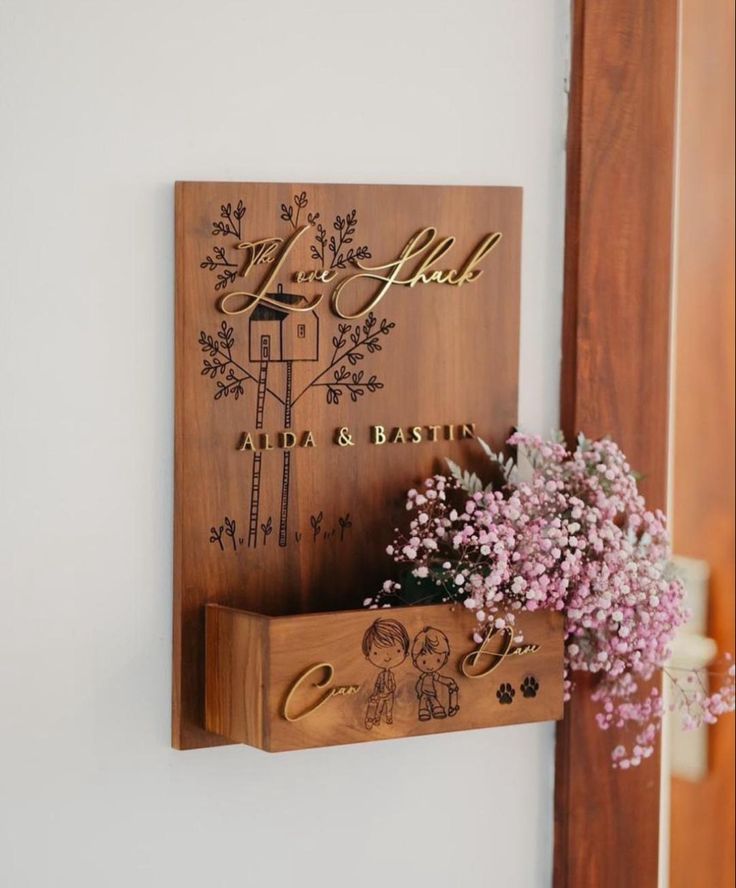 a couple of wooden signs mounted to the side of a wall next to a vase with flowers