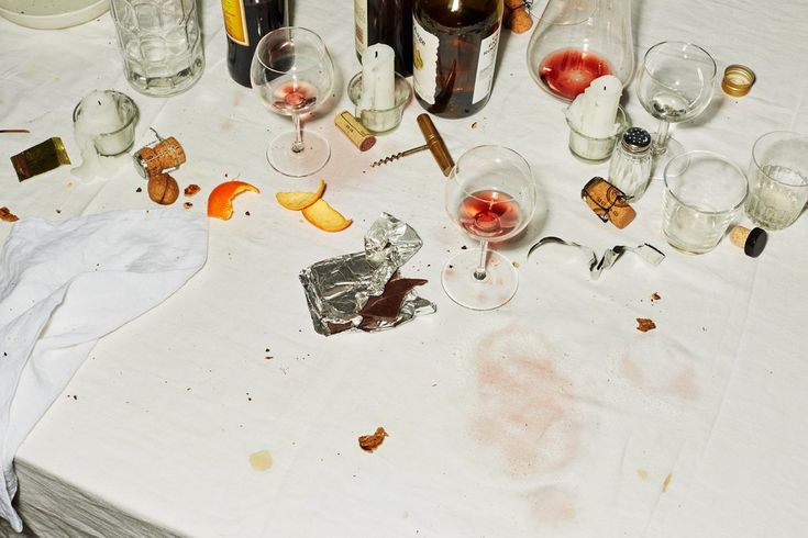 the table is covered with wine glasses and other items that have been left on it