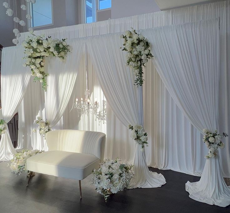 a white wedding setup with flowers and chandelier