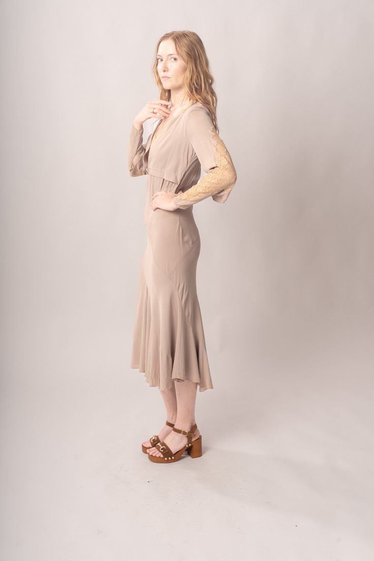 Stunningly preserved 1920’s mauve & ecru bias cut dress with attached jacket, lace trim, and asymmetrical cut. Best fits modern size S-M Length 52”Pit to pit 18.5”Waist 26-30”Hips 31-42” Model’s Measurements:Height 5’9”Chest 34”Waist 29”Hips 36.5” Excellent vintage condition, with normal wear and condition for its age.For international shipping rates, please send inquiries to our CONTACT page. Fitted Bias Cut Dresses For Fall, Fitted Long Sleeve Bias Cut Midi Dress, Fitted Lace Trim Midi Dress For Fall, Fitted Knee-length Taupe Dress, Fitted Taupe Knee-length Dress, Taupe Fitted Knee-length Dress, Cream Fitted Midi Dress With Lace Trim, Fitted Cream Midi Dress With Lace Trim, Fitted Taupe Midi Length Dress