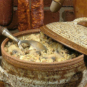 a large bowl filled with food next to a brick wall